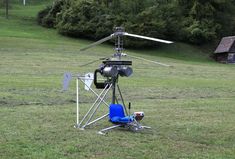 a helicopter sitting on top of a lush green field next to a blue lawn chair