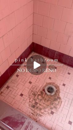 a dirty bathroom with pink walls and tile floor