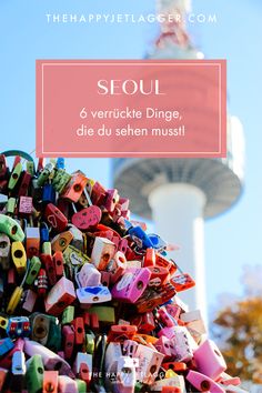 a pile of colorful magnets in front of the space needle tower with text overlay saying seou 6 vertuckte dingge dien