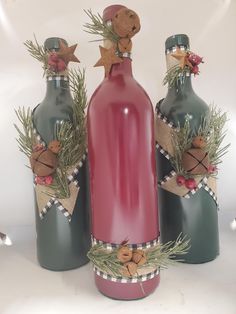 three wine bottles decorated with christmas decorations