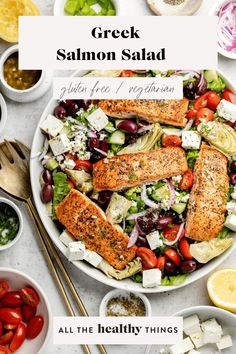 a salad with salmon, lettuce, tomatoes, cucumbers and other ingredients