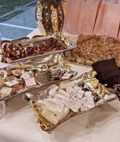 an assortment of desserts and pastries on display in front of a glass window