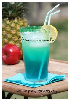 a blue lemonade drink sitting on top of a wooden table next to an apple