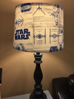 a star wars lamp shade on top of a table next to a black leather chair