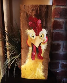 a painting of a chicken on a wooden block