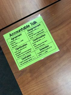 a close up of a sign on a wooden table