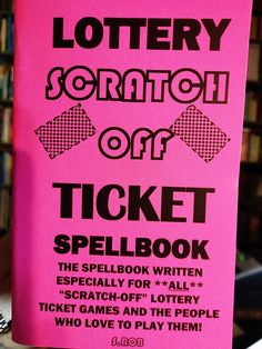 a pink ticket book sitting on top of a table next to a pile of books