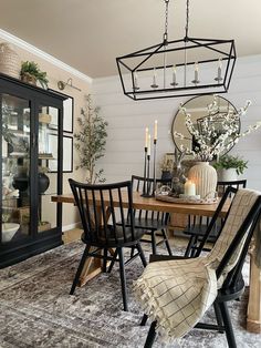 a dining room table and chairs with candles on it