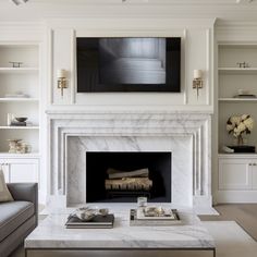 a living room filled with furniture and a fire place in front of a white fireplace