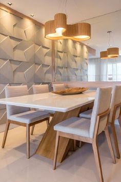 a dining room table and chairs in front of a wall with geometric designs on it