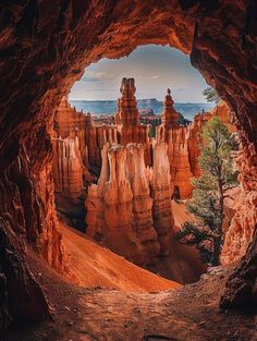 the inside of a rock formation with trees and mountains in the background