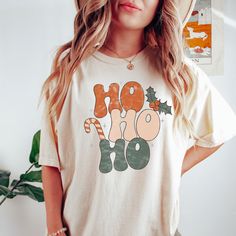 a woman wearing a t - shirt with the word ho hoo on it and holly decorations