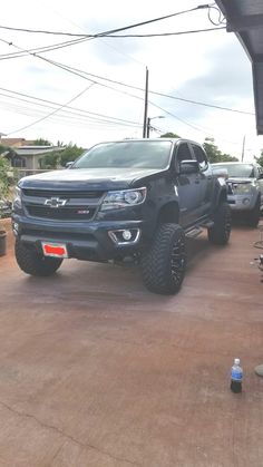 the truck is parked on the side of the road in front of other cars and trucks