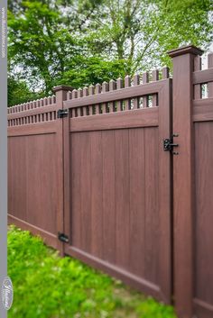 a brown wooden fence surrounded by green grass