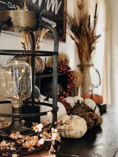 a table with pumpkins, gourds and other decorations