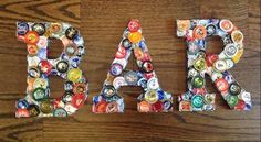 two letters made out of bottle caps are sitting on a wooden table with the word fala written in it