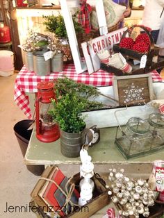 the table is covered with christmas decorations and other items for sale in front of people