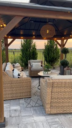 an outdoor patio with wicker furniture and string lights