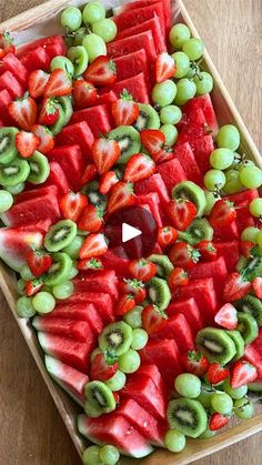 watermelon, kiwi and grapes arranged on a platter for a party