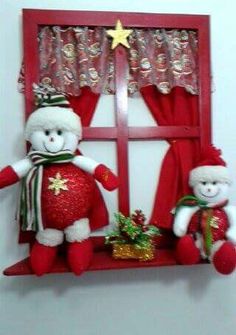 two teddy bears are sitting on a window sill with christmas decorations in front of them