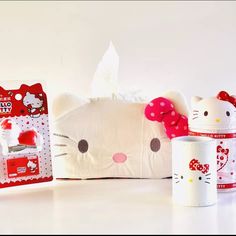 two hello kitty mugs, one with a bow and the other with a tissue dispenser