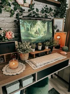 a desk with a computer and plants on it