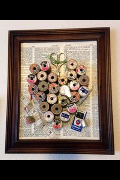 an art piece made out of donuts on top of a book page in a wooden frame