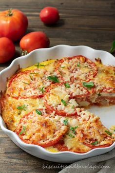 a pizza pie with tomatoes and cheese in the middle on a plate next to some cherry tomatoes