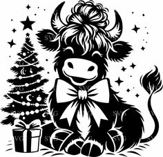 a black and white cow sitting next to a christmas tree