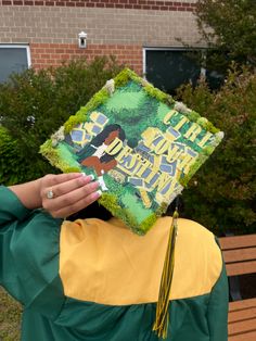 a person wearing a green and yellow graduation cap with the words, i have never seen this