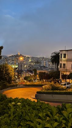 the city is lit up at night with lights shining on it's buildings and trees