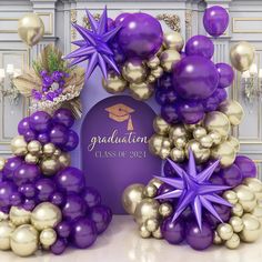 purple and gold graduation decorations on display in front of a white plaque with congratulations written on it