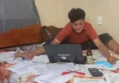 a woman laying on top of a bed next to a laptop computer