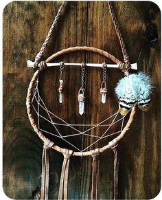 a dream catcher hanging on the side of a wooden wall