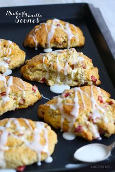 several scones with icing on a black tray