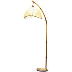 a floor lamp with a white shade on it's head and a metal base