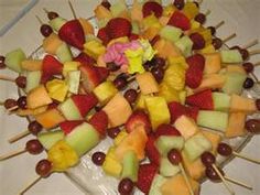 a platter filled with fruit and skewers