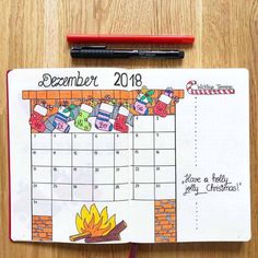 a calendar with an image of a campfire on it and a pen next to it