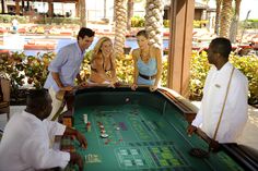 four people playing crapo table at an outdoor casino