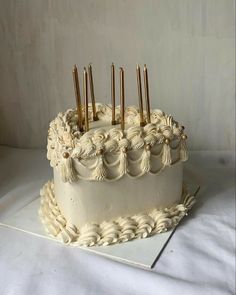 a white cake with gold candles on it