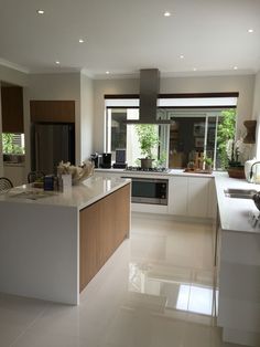 a large kitchen with white counter tops and wooden cabinets