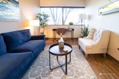 a living room with two couches and a coffee table in front of a window