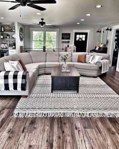 a living room filled with furniture and a large rug on top of a hard wood floor