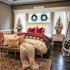 a bedroom decorated for christmas with wreaths on the window sill and plaid bedding