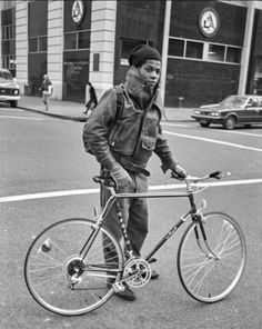 a man standing next to his bike on the street