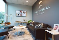 a living room filled with furniture next to a large glass window and a sign that reads billi dental studio