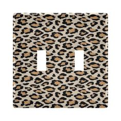 an animal print light switch plate cover in beige and black, with a leopard pattern on it