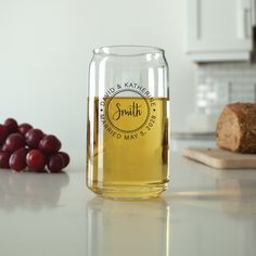 a glass jar filled with liquid sitting on top of a counter next to some grapes