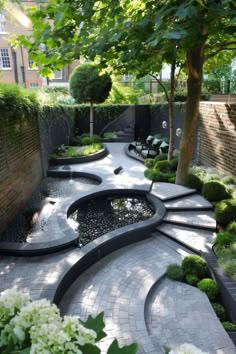 an outdoor garden with stone walkways and water feature, surrounded by white hydrangeas