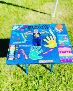 a blue table covered in stickers and handprints on the top of it